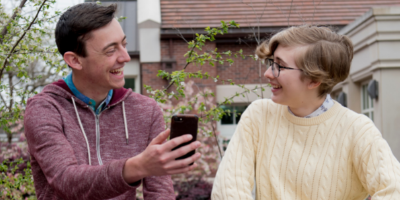 2 Students Sittign in front of the Library