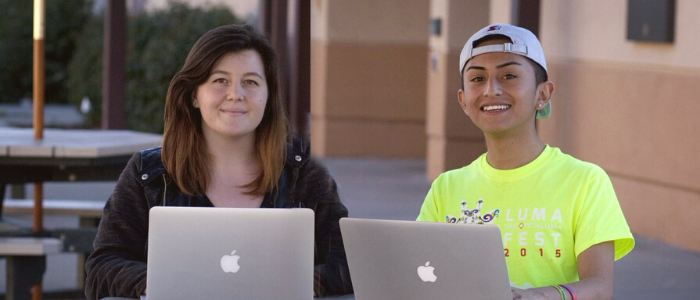 two female students using their laptop