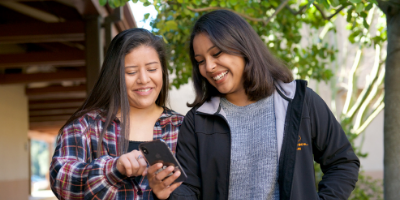 two female students on their cellphone